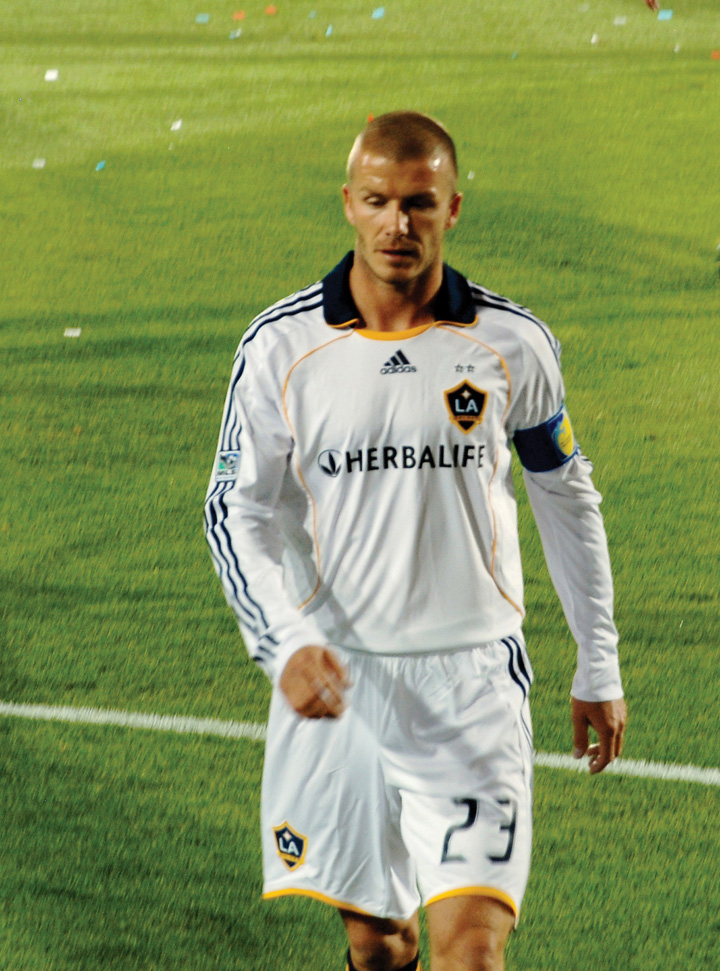 This picture shows David Beckham walking across a playing field in an L.A. Galaxy team jersey.