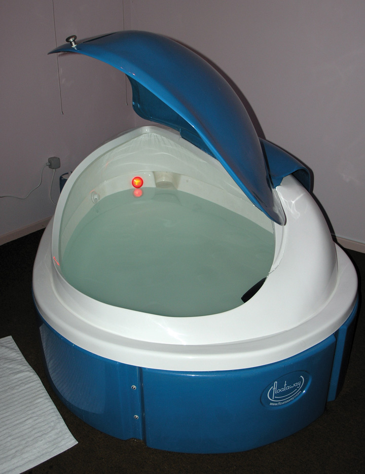 This picture shows an open door to an empty sensory deprivation tank.