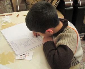 This picture shows a young boy writing a test.