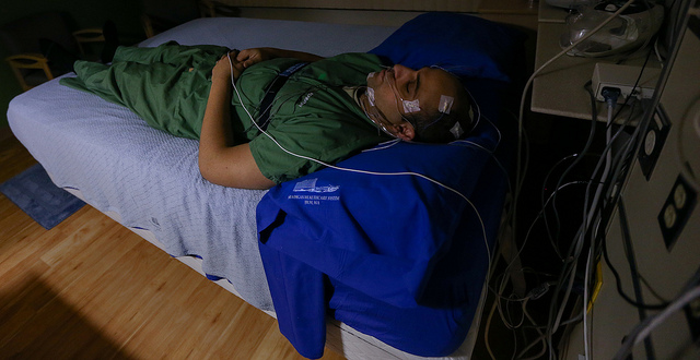 This picture shows a man sleeping with monitoring devices attached to him.