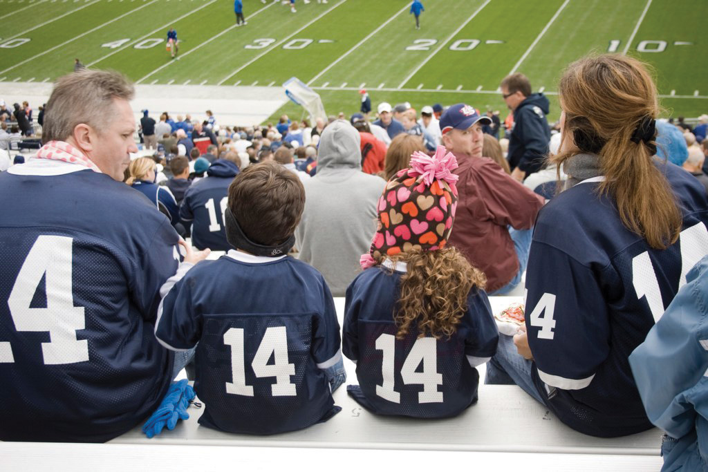 This picture shows a family wearing matching jerseys at a football game.