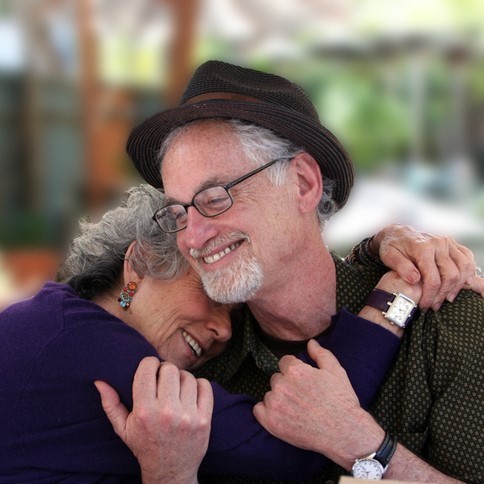 This picture shows a grey-haired couple sharing an affectionate hug.