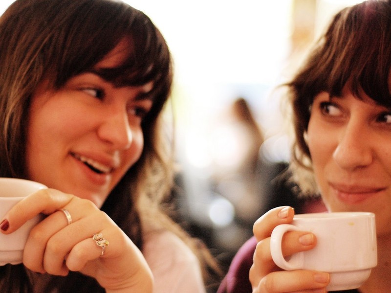 This picture shows two friends having a conversation over coffee.
