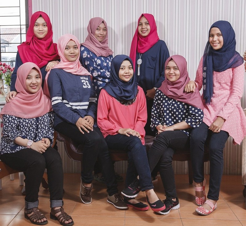 This picture shows a group of Malaysian teen girls posed for a photo wearing casual clothing and traditional head scarves.